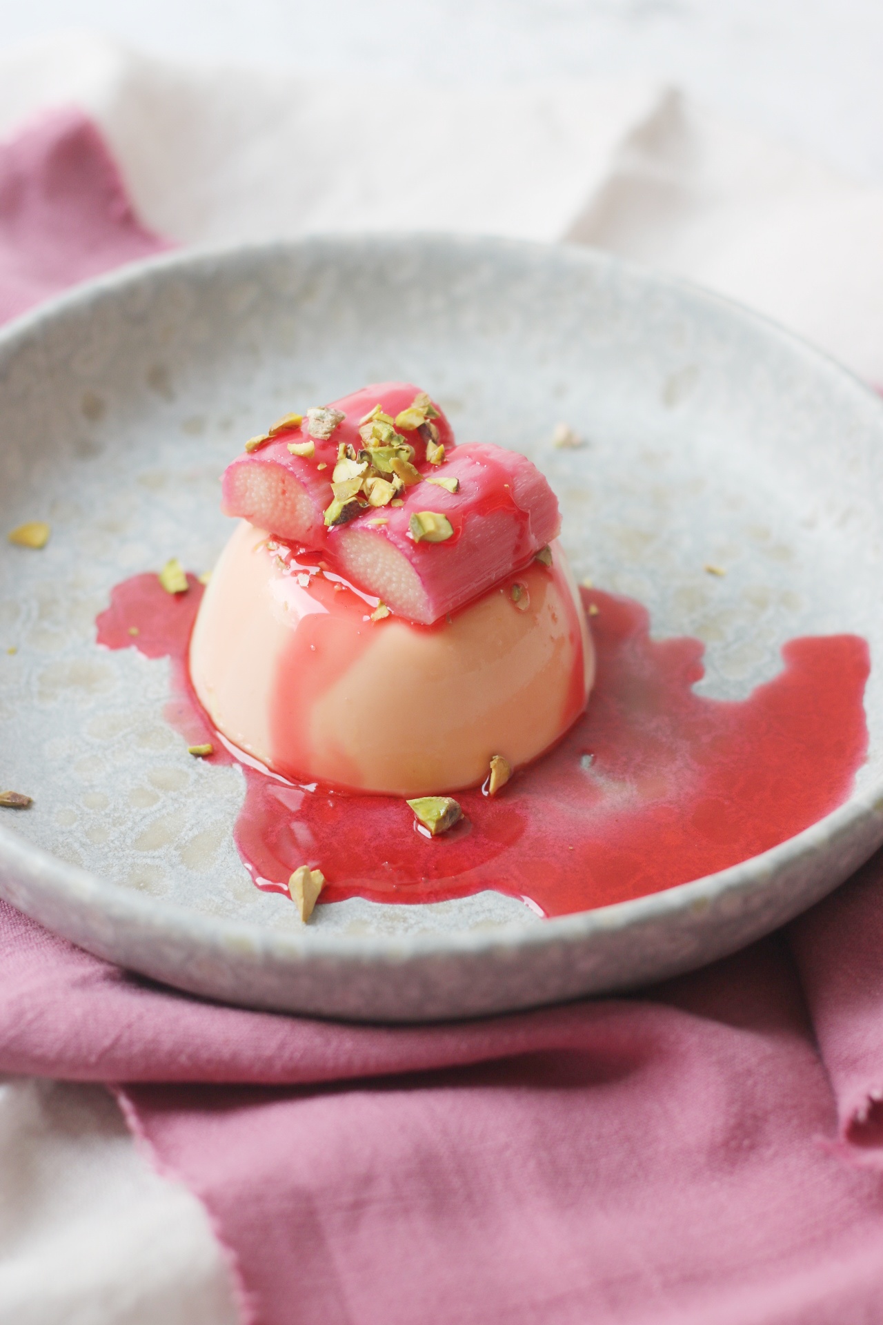 Vegan Panna Cotta topped with poached rhubarb and pistachio